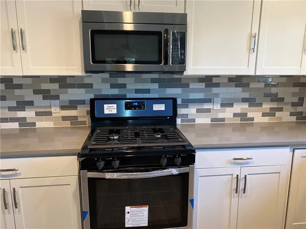 a kitchen with stainless steel appliances granite countertop a stove and a microwave