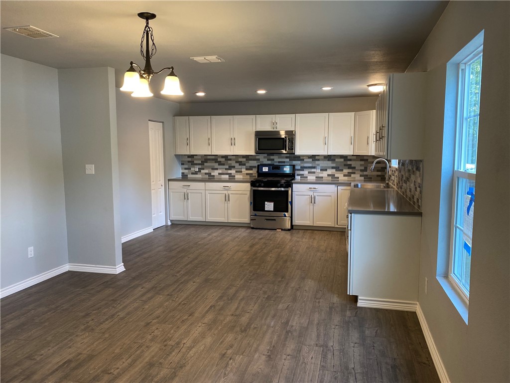 6107 Carnation Terrace Austin, TX 78741 - Photo 6 of 27 a kitchen with a refrigerator and a stove top oven