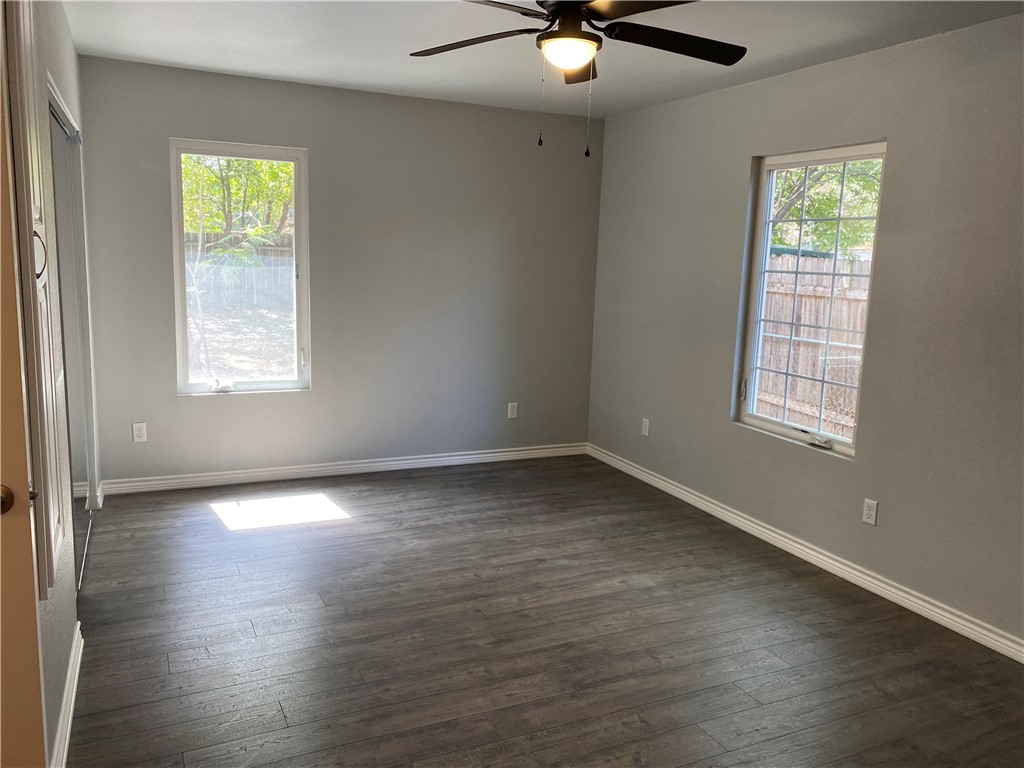 6107 Carnation Terrace Austin, TX 78741 - Photo 10 of 27 an empty room with wooden floor fan and windows