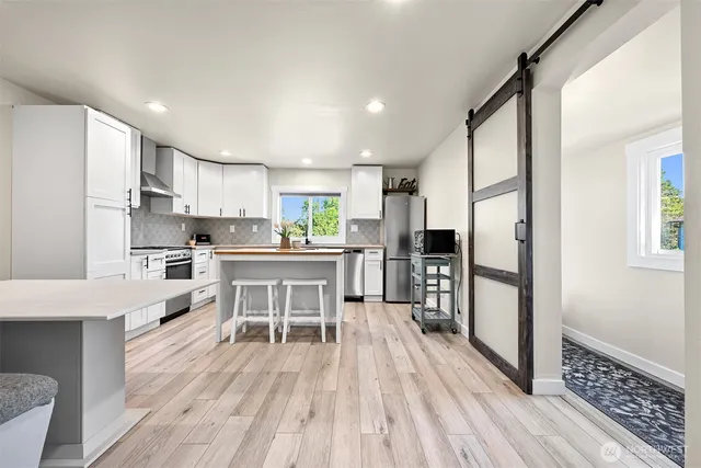 a kitchen with white cabinets and stainless steel appliances