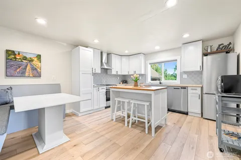 a kitchen with a table chairs refrigerator and a sink