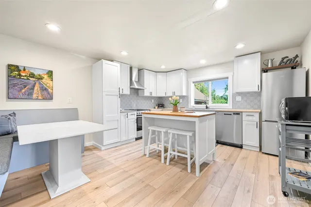 a kitchen with a table chairs refrigerator and a sink