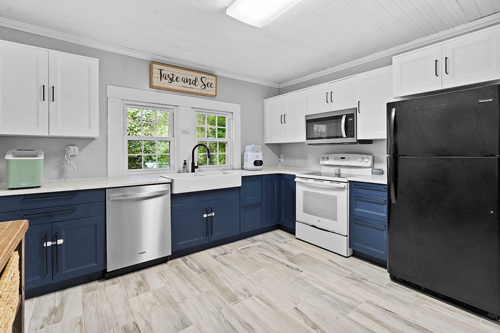 2176 Longview Road Cross Hill, SC 29332 - Photo 8 of 17 a kitchen with stainless steel appliances granite countertop a refrigerator a sink dishwasher a stove top oven a refrigerator and white cabinets with wooden floor