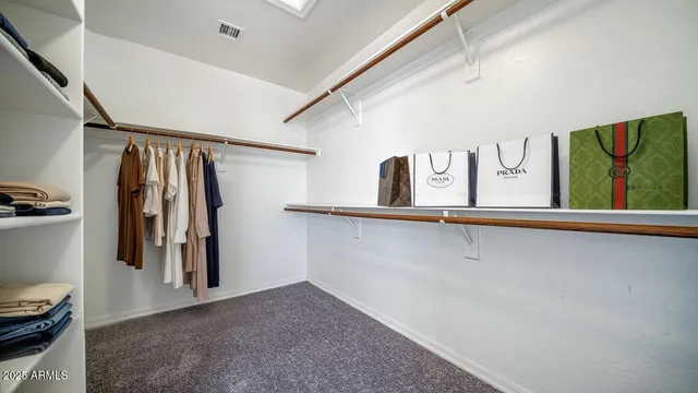 a view of walk in closet with clothes and shoes