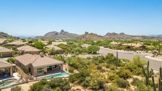 an aerial view of a house with a mountain