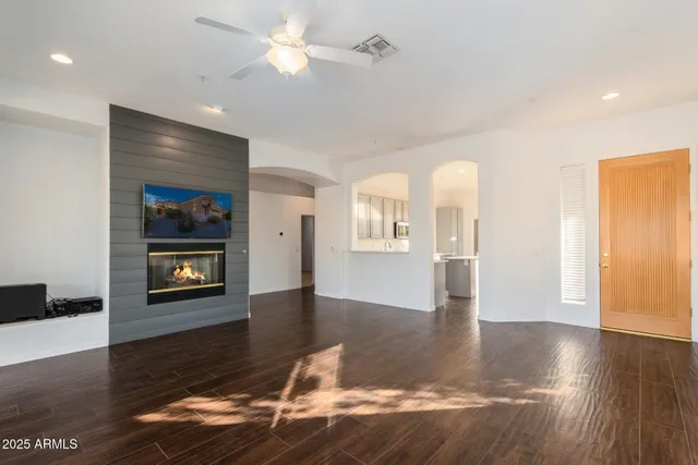 a view of an empty room with window and wooden floor