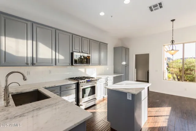 a kitchen with a sink appliances and cabinets