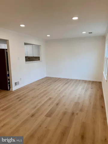 a view of empty room with wooden floor and windows