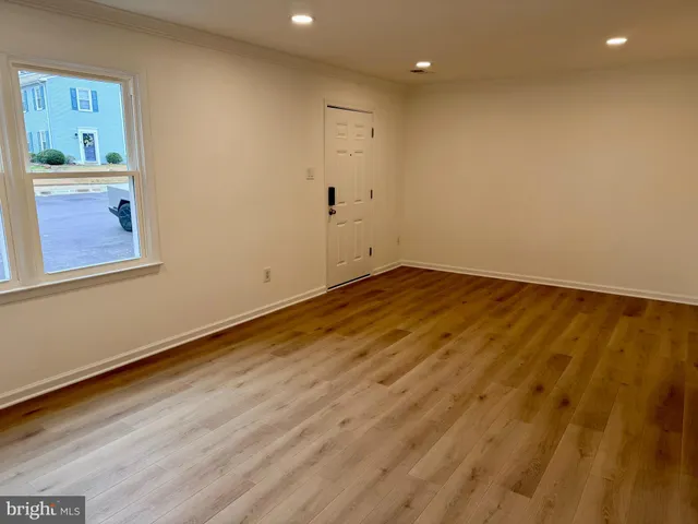 a view of a hallway with wooden floor and a window