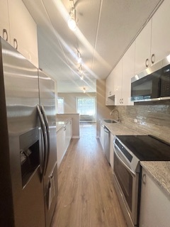 2215 West 111th Street, Unit 101 Chicago, IL 60643 - Photo 11 of 39 a kitchen with stainless steel appliances granite countertop a refrigerator a stove and a sink