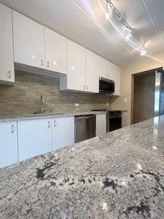 a kitchen with granite countertop a sink and a stove