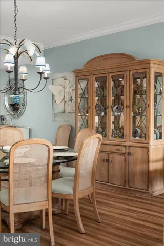 a bedroom with a bed a dresser and wooden floor