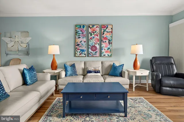 a kitchen with stainless steel appliances granite countertop a stove a sink a refrigerator a stove a dining table and chairs with wooden floor