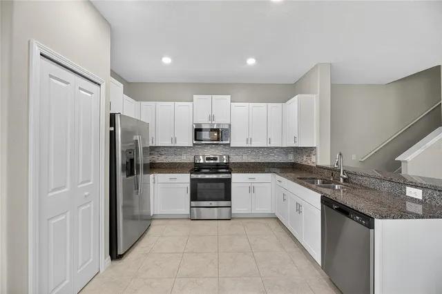 a kitchen with stainless steel appliances granite countertop a refrigerator sink and cabinets
