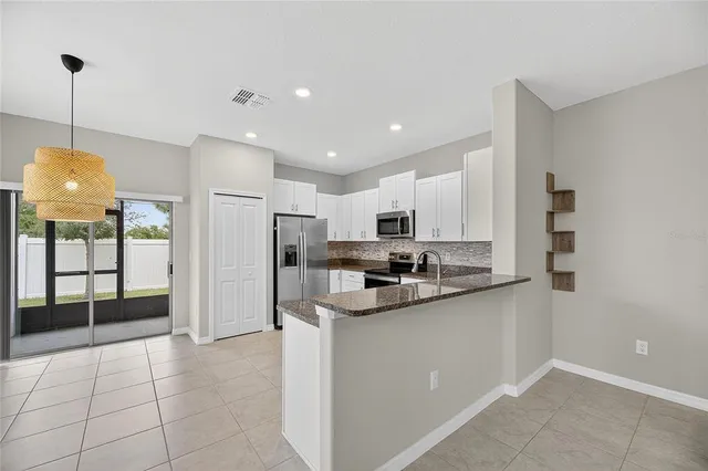 a kitchen with granite countertop a sink and white cabinets