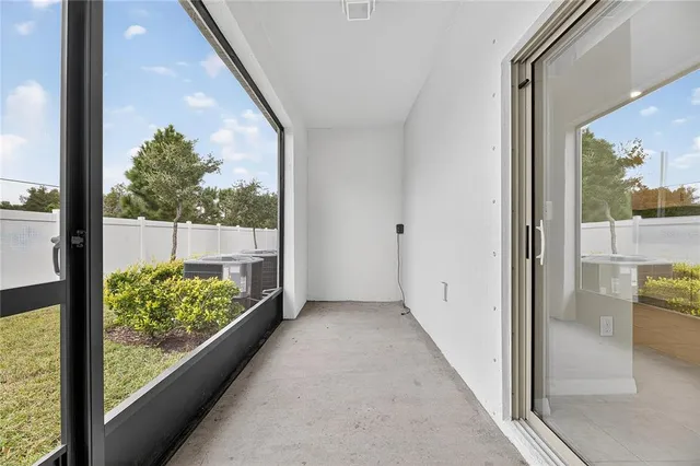 an empty room with ceiling fan and window