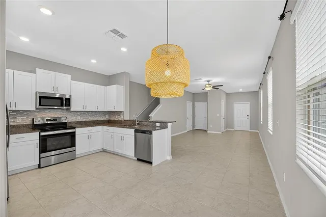 a kitchen with stainless steel appliances granite countertop a sink a stove and a window