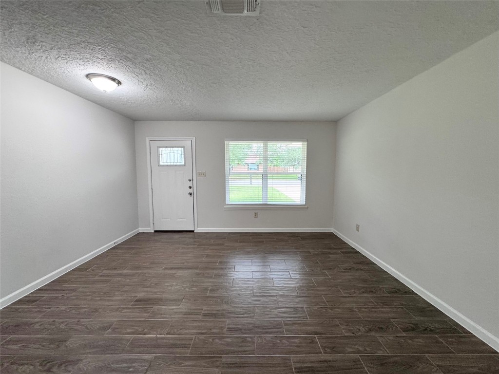 2402 Barak Lane Bryan, TX 77802 - Photo 17 of 25 an empty room with wooden floor and windows