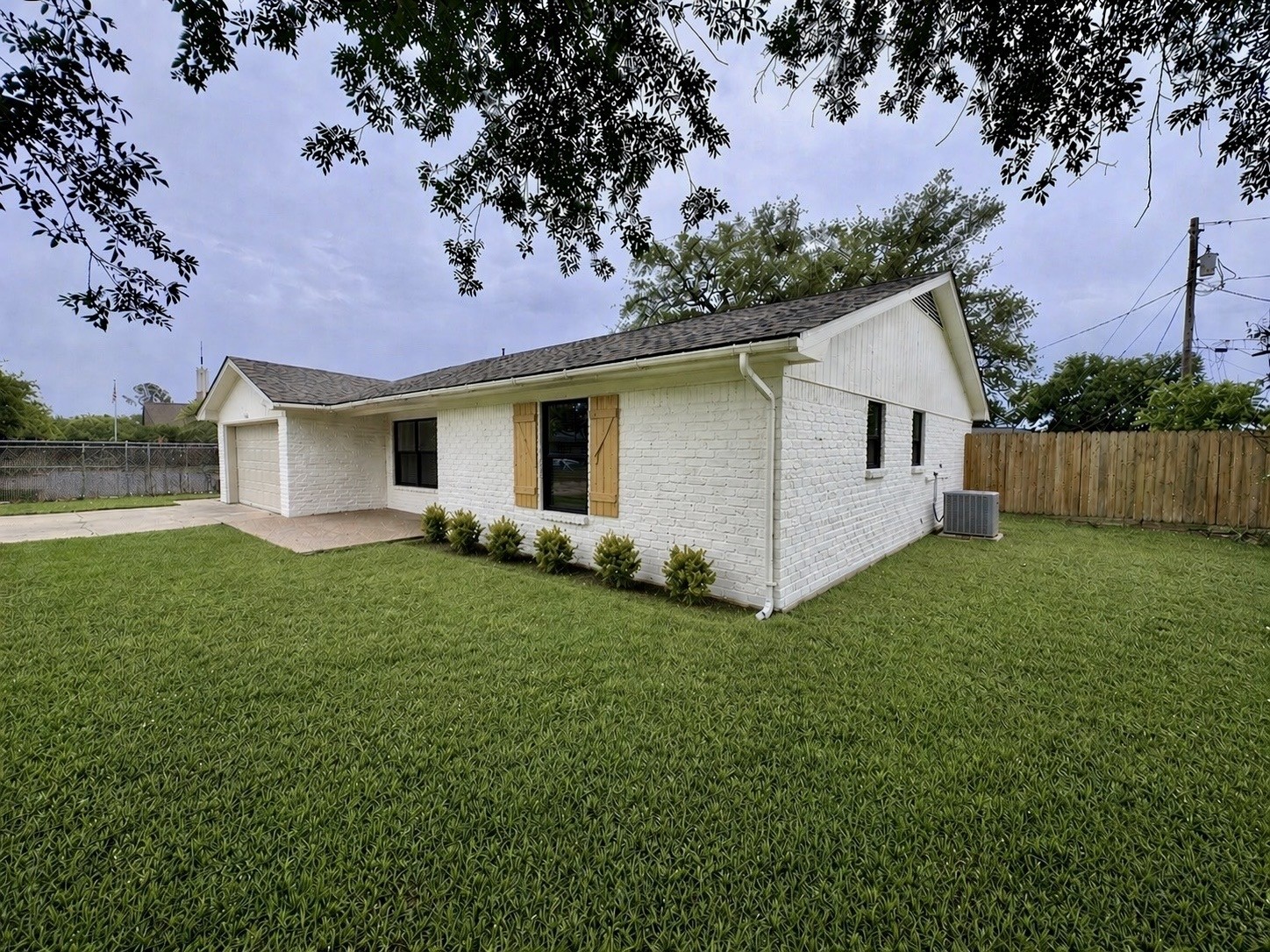 2402 Barak Lane Bryan, TX 77802 - Photo 2 of 25 a view of a backyard with plants and large tree