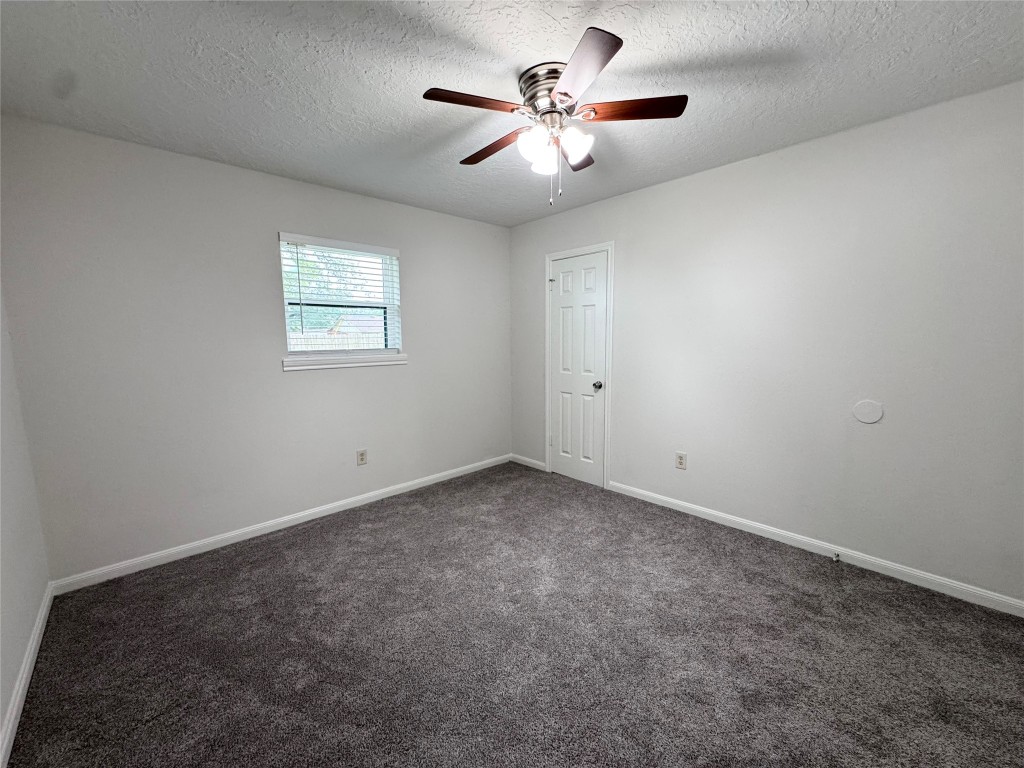 2402 Barak Lane Bryan, TX 77802 - Photo 22 of 25 an empty room with a chandelier fan and windows