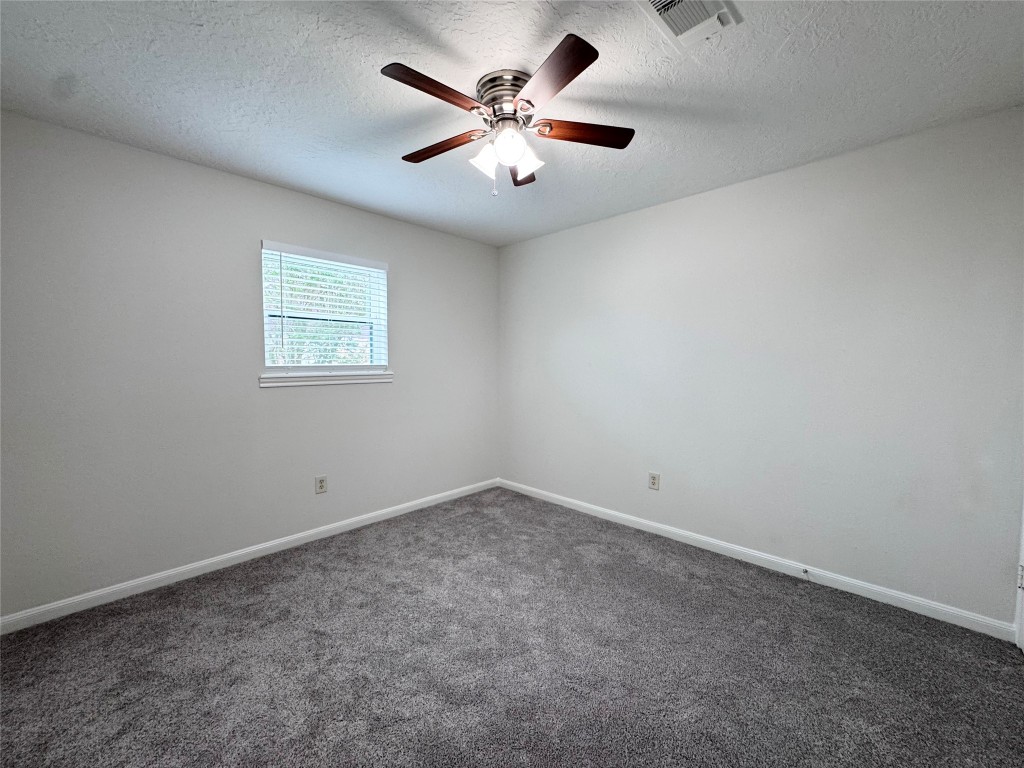 2402 Barak Lane Bryan, TX 77802 - Photo 23 of 25 an empty room with windows and ceiling fan