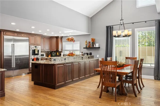 a kitchen with stainless steel appliances granite countertop a table and chairs in it