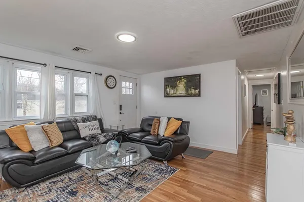 a living room with furniture wooden floor and a large window