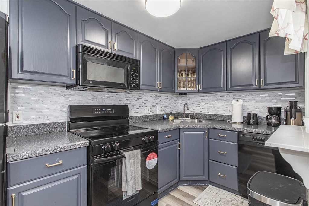 7 Scannell Road Randolph, MA 02368 - Photo 19 of 34 a kitchen with a sink stove and microwave