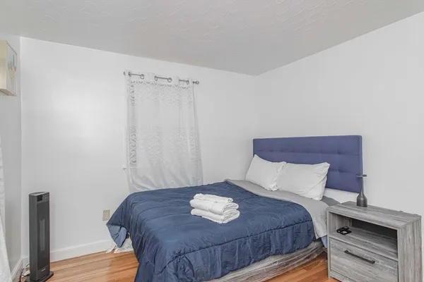 a bedroom with a bed and wooden floor