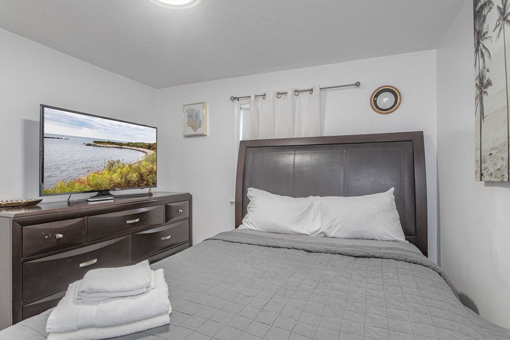 7 Scannell Road Randolph, MA 02368 - Photo 30 of 34 a bedroom with a bed and a flat screen tv