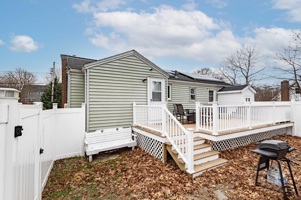 7 Scannell Road Randolph, MA 02368 - Photo 4 of 34 a white house that has a small yard and a large window