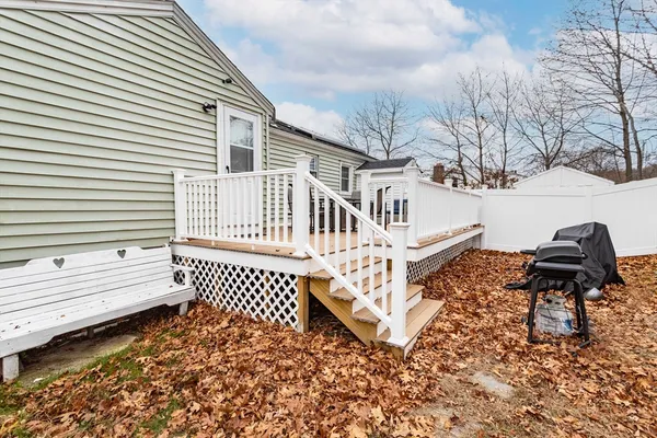 a view of a house with backyard and wooden fence