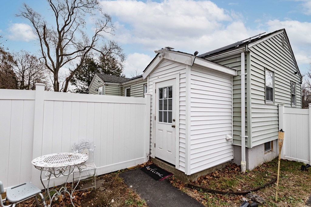 7 Scannell Road Randolph, MA 02368 - Photo 8 of 34 a view of a white house with a white wooden fence and a large tree