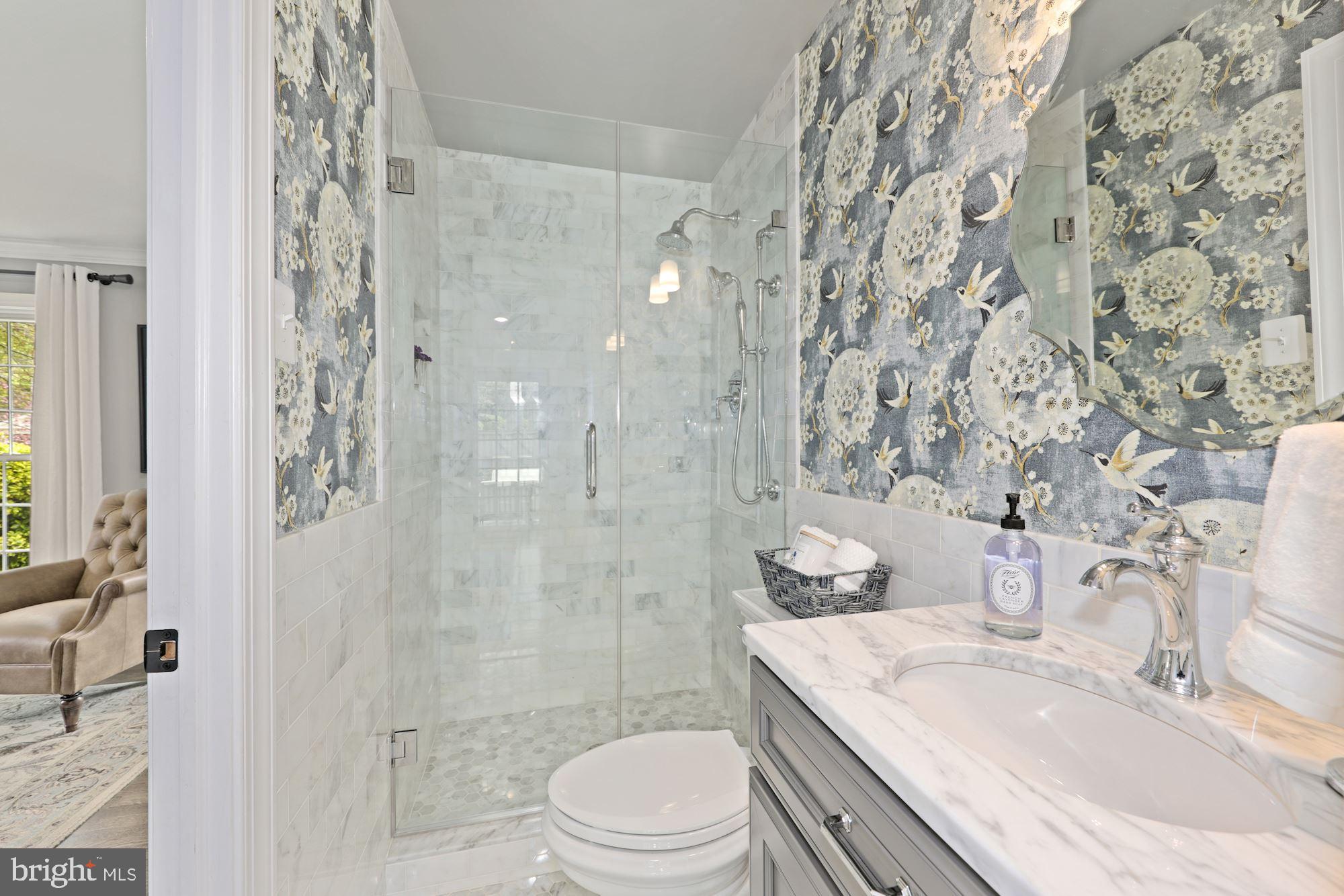 5500 Pollard Road Bethesda, MD 20816 - Photo 40 of 70 a bathroom with a granite countertop sink a toilet a mirror and shower