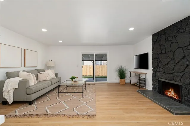 a living room with furniture a flat screen tv and a fireplace