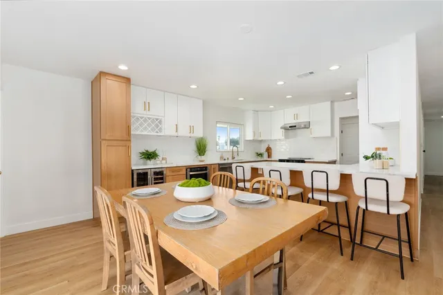 a kitchen with a dining table chairs and wooden floor