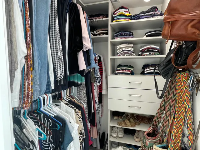 a view of walk in closet with clothes and shoes