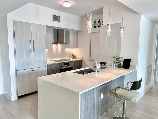 a kitchen with stainless steel appliances a sink and a refrigerator