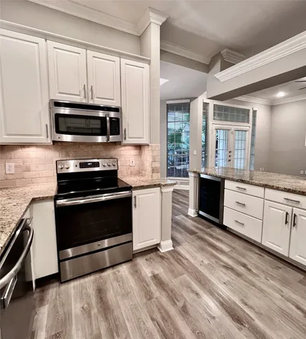 a kitchen with stainless steel appliances granite countertop a stove a sink and a microwave