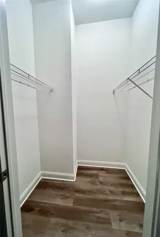 a view of walk in closet with wooden floor