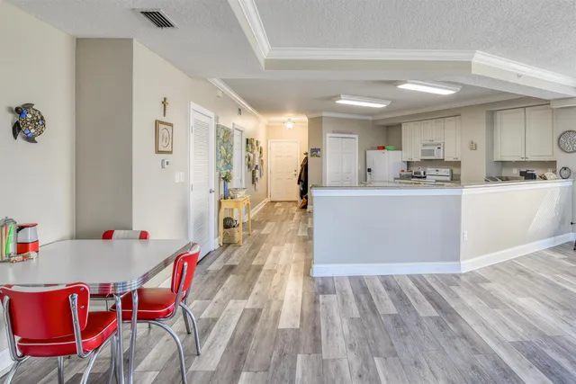a kitchen with granite countertop a dining table chairs and white appliances