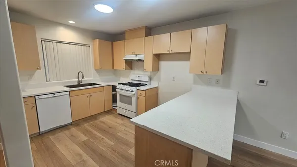 a kitchen with a sink a refrigerator and white cabinets