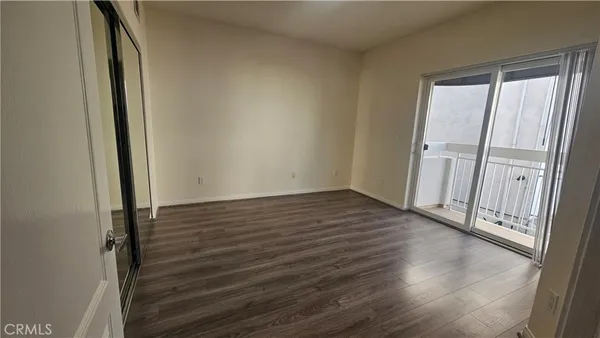 an empty room with wooden floor and entrance