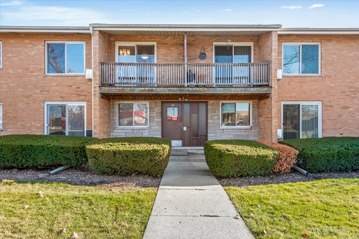 681 Elmhurst Road, Unit E Mount Prospect, IL 60056 - Photo 1 of 20 a front view of a house with a garden and plants