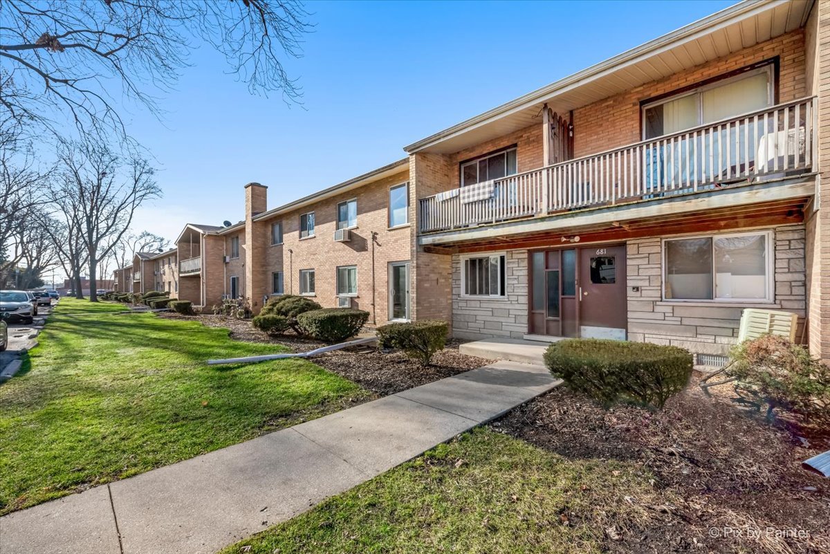 681 Elmhurst Road, Unit E Mount Prospect, IL 60056 - Photo 18 of 20 a front view of a house with a yard