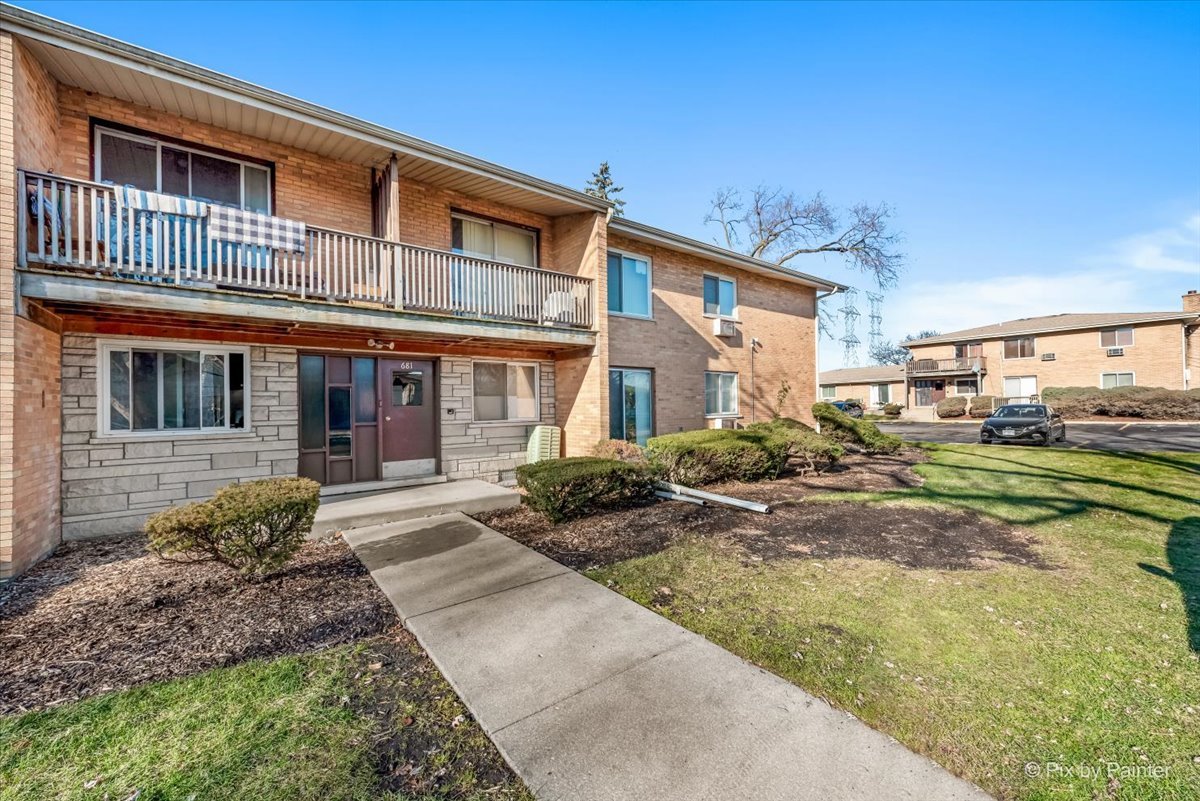681 Elmhurst Road, Unit E Mount Prospect, IL 60056 - Photo 19 of 20 a front view of a house with a yard