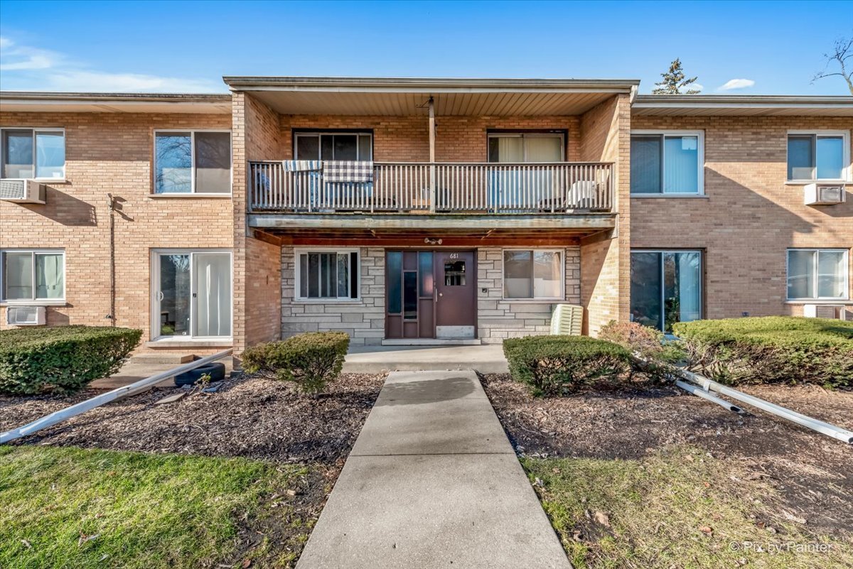 681 Elmhurst Road, Unit E Mount Prospect, IL 60056 - Photo 20 of 20 a front view of a house with garden and porch
