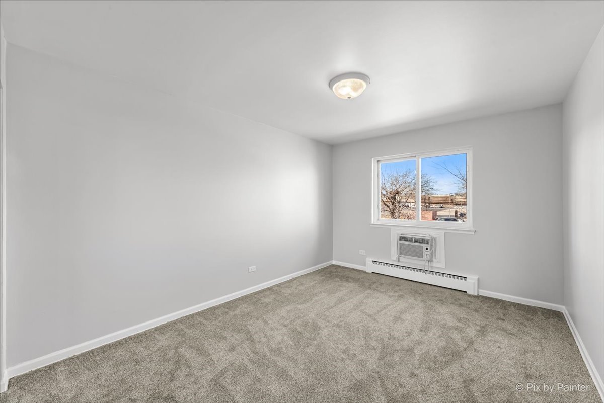 681 Elmhurst Road, Unit E Mount Prospect, IL 60056 - Photo 9 of 20 an empty room with windows