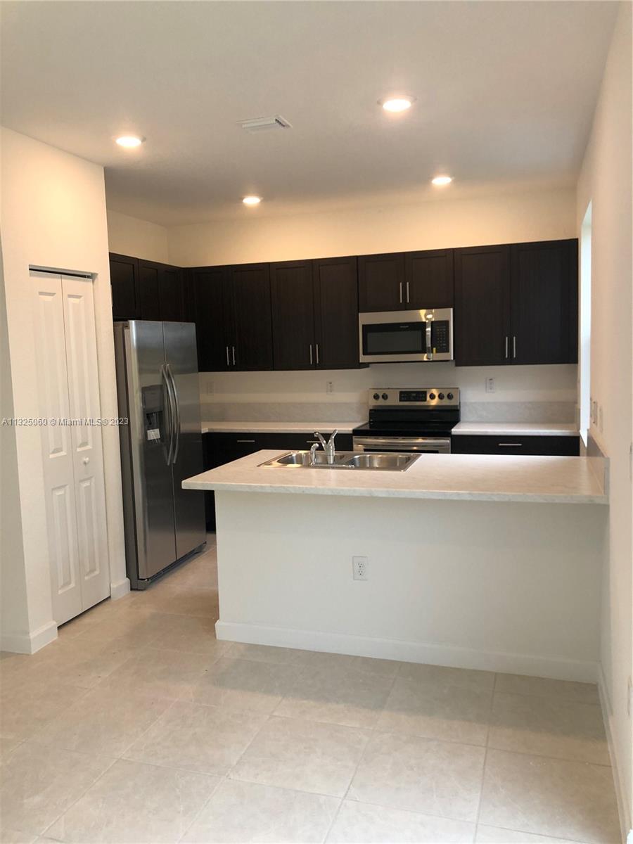 2610 Southeast 13th Street Homestead, FL 33035 - Photo 3 of 17 a view of kitchen with stainless steel appliances granite countertop cabinets and microwave