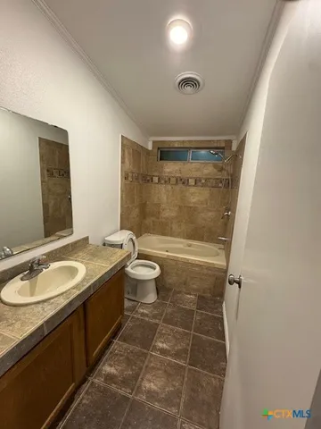 a bathroom with a granite countertop sink toilet a mirror and shower